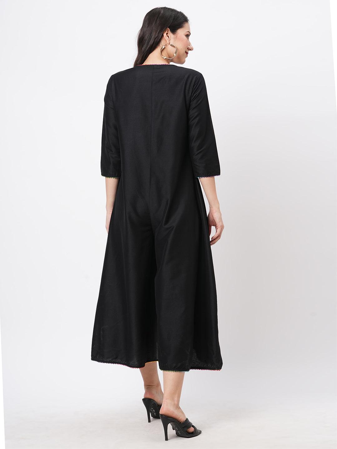 Hashtag Be featuring a black silk blend below calf jumpsuit with multi color trim at the neck and sleeve hem