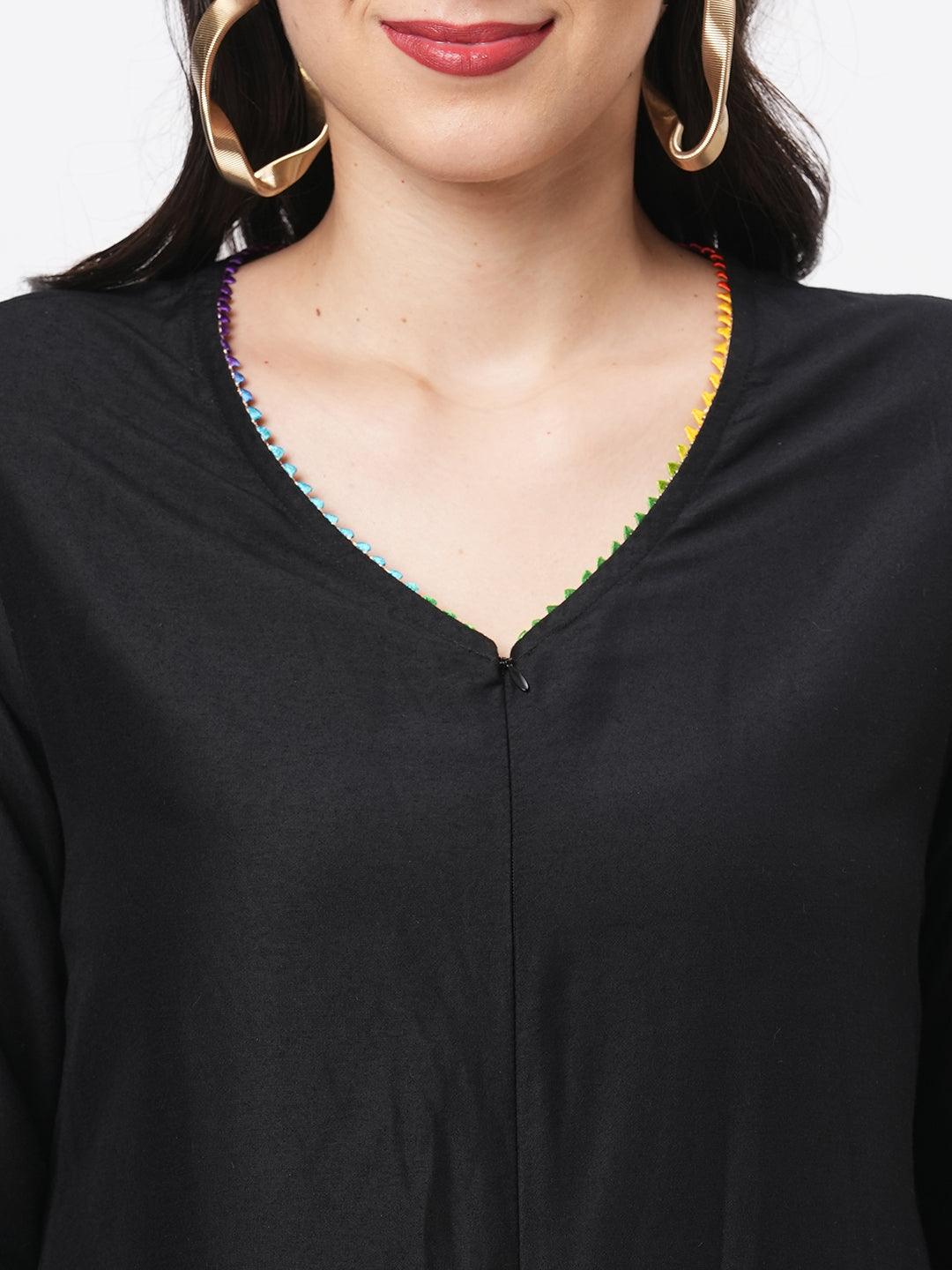 Hashtag Be featuring a black silk blend below calf jumpsuit with multi color trim at the neck and sleeve hem
