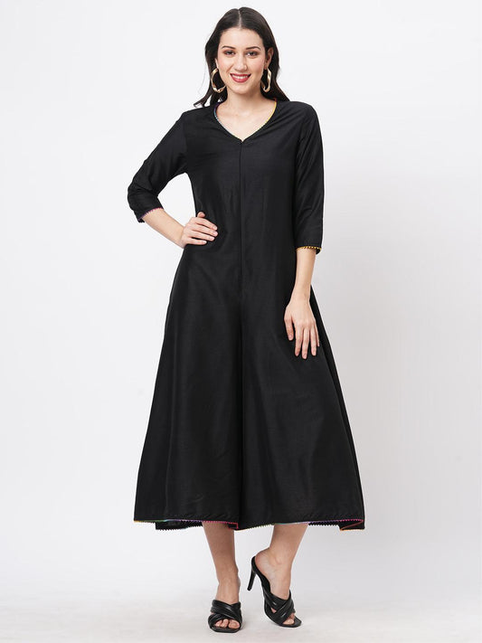 Hashtag Be featuring a black silk blend below calf jumpsuit with multi color trim at the neck and sleeve hem