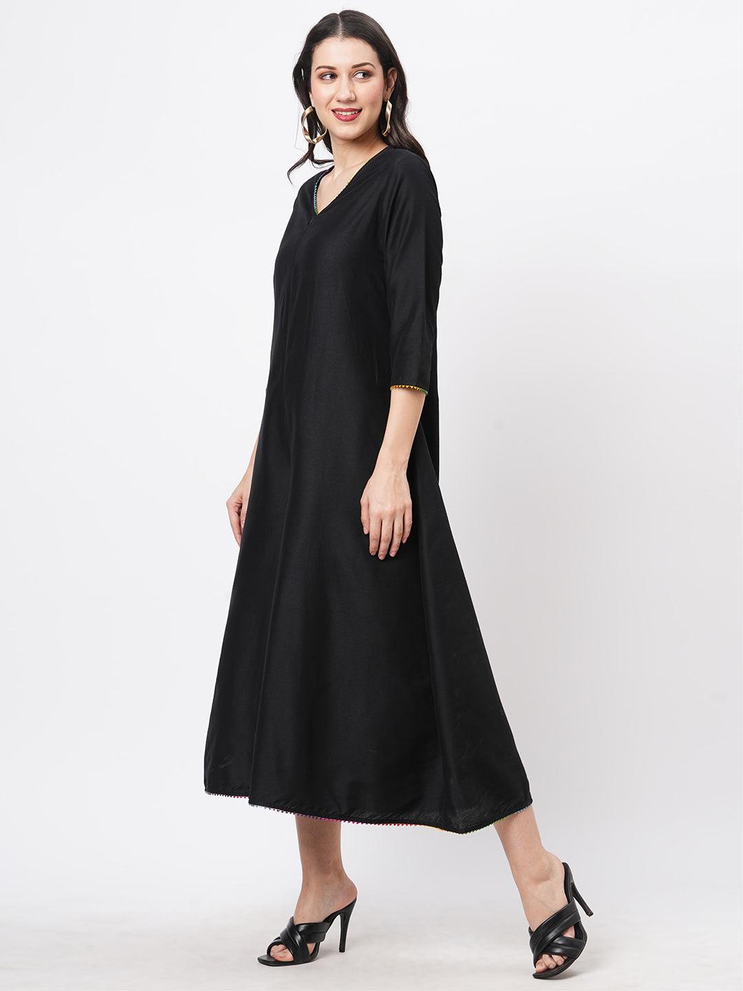 Hashtag Be featuring a black silk blend below calf jumpsuit with multi color trim at the neck and sleeve hem