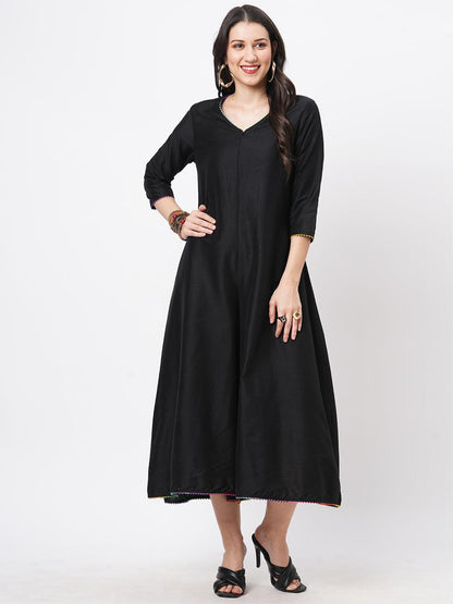 Hashtag Be featuring a black silk blend below calf jumpsuit with multi color trim at the neck and sleeve hem