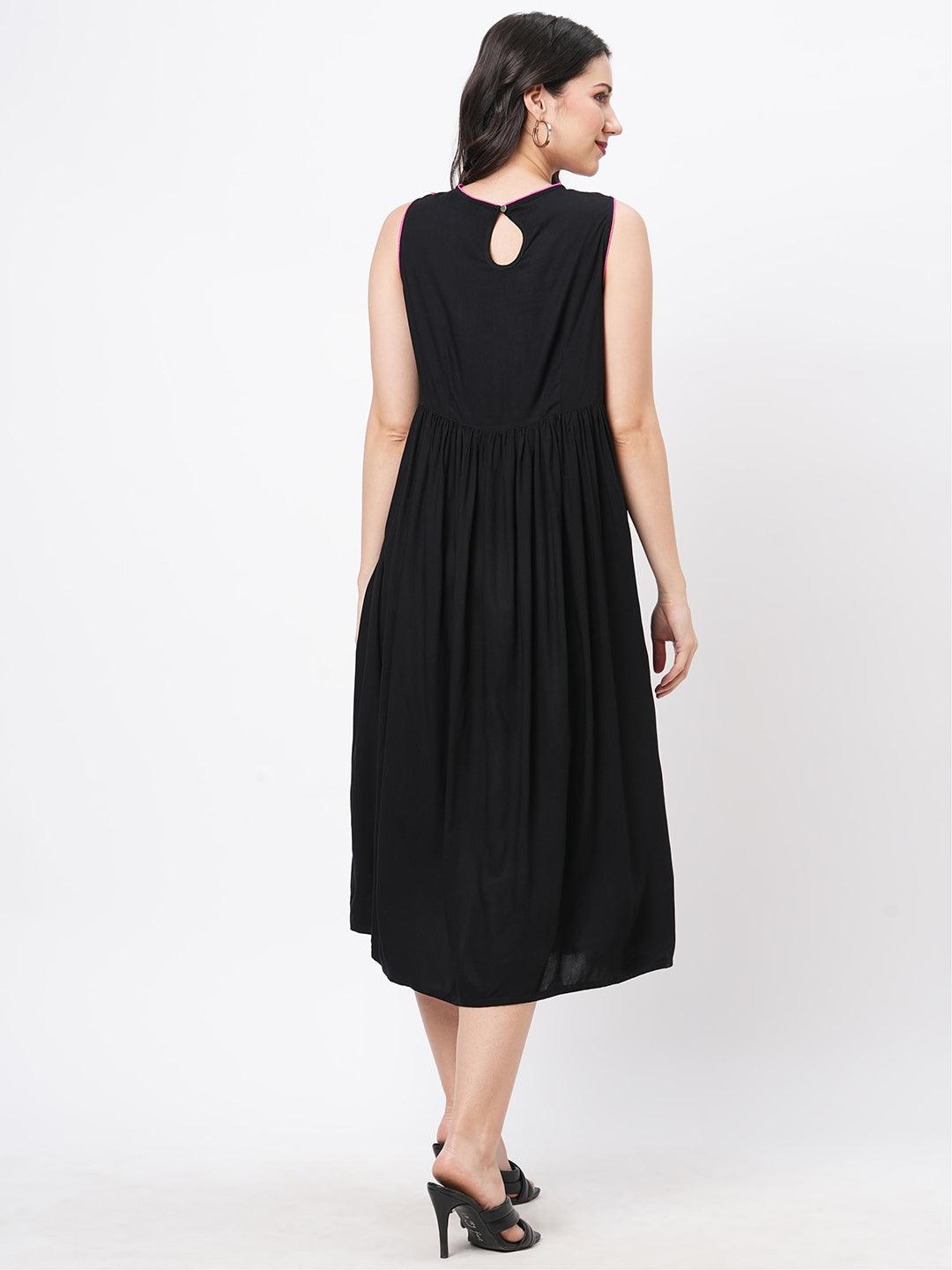 Hashtag Be Featuring a black boho calf length airy dress with tassel and embroidery