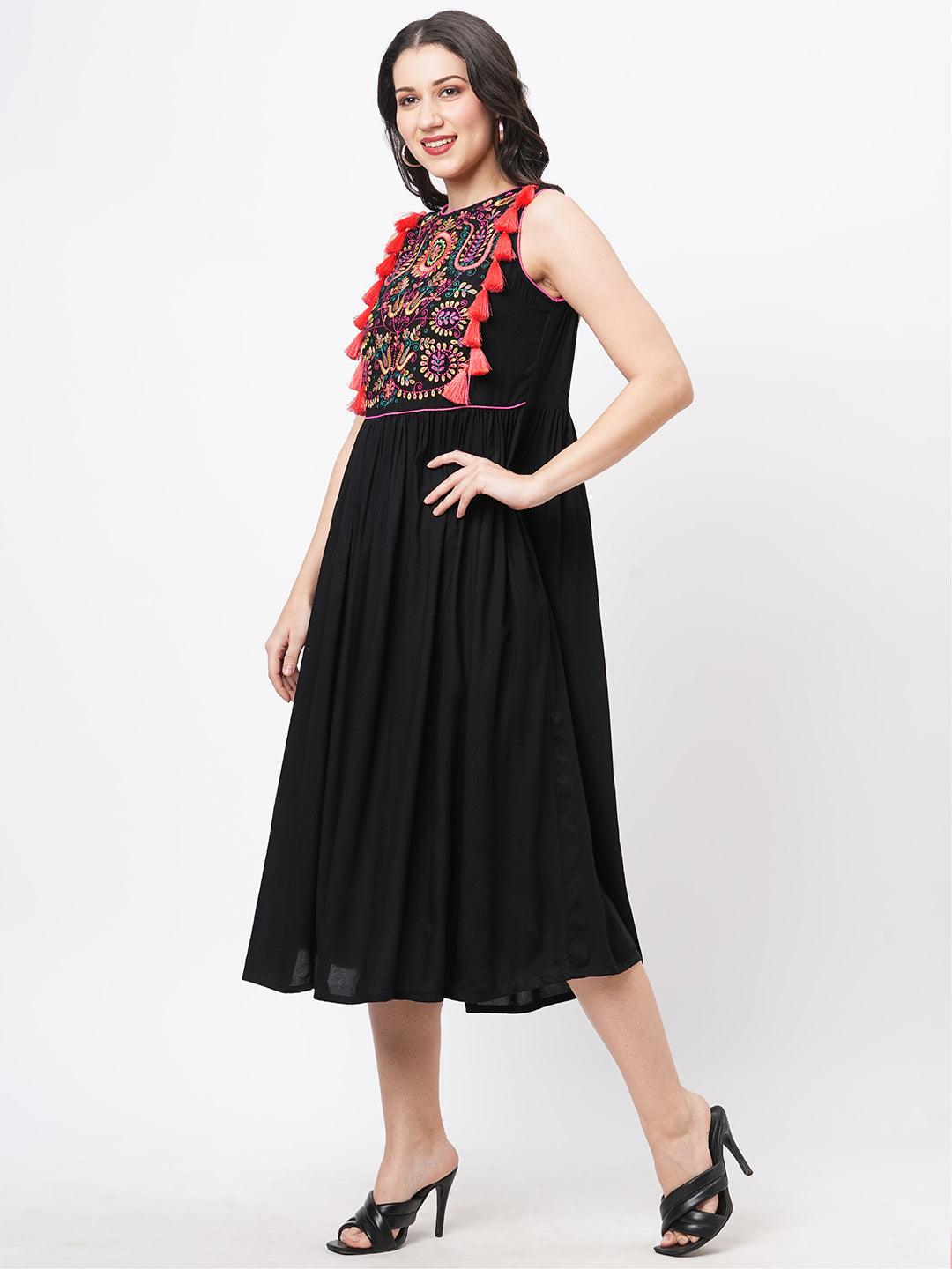Hashtag Be Featuring a black boho calf length airy dress with tassel and embroidery