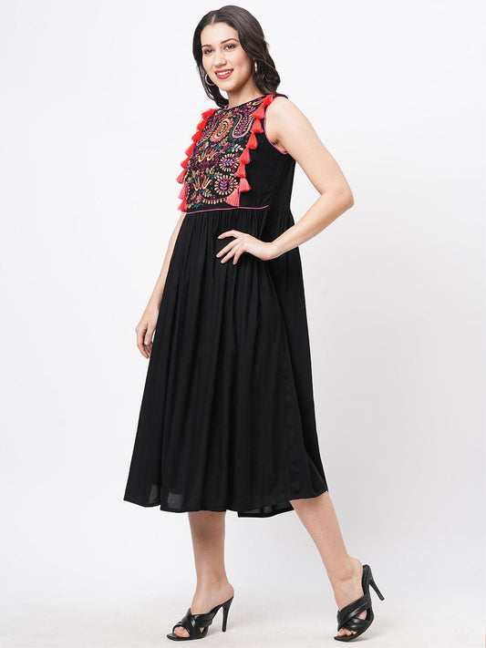 Hashtag Be Featuring a black boho calf length airy dress with tassel and embroidery