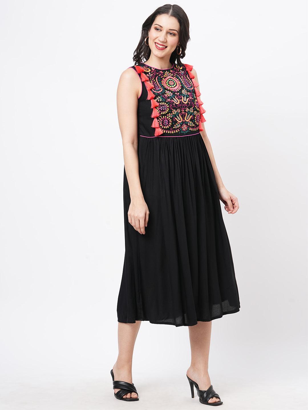 Hashtag Be Featuring a black boho calf length airy dress with tassel and embroidery