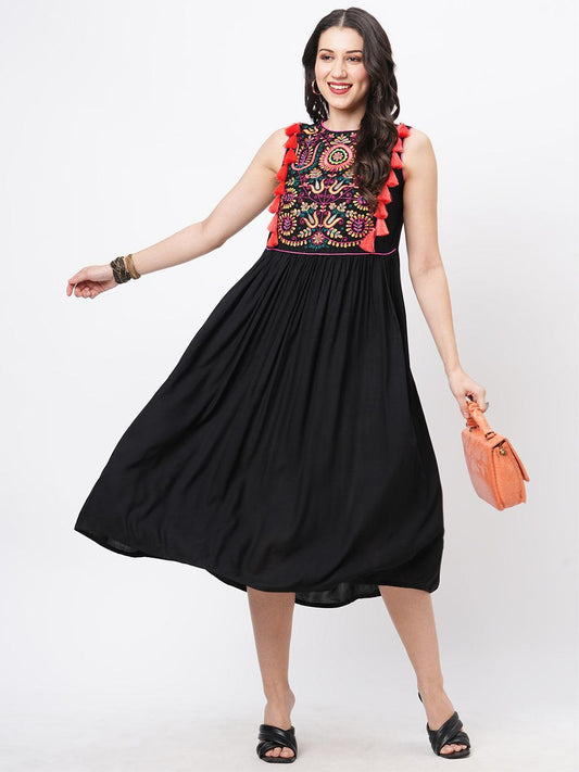 Hashtag Be Featuring a black boho calf length airy dress with tassel and embroidery