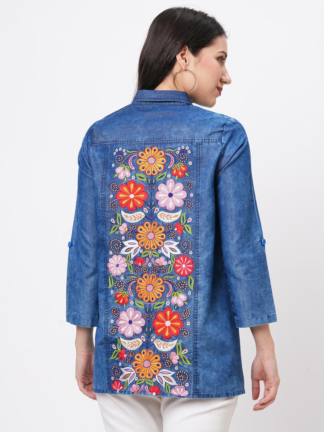Hashtag Be Denim blue in sturdy washed cotton shirt with collar and button down front and high low hem with embroidery at the back